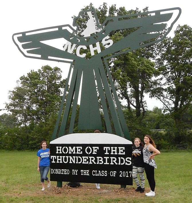 North Callaway High School seniors, from left, Taylor Bates, A.J. Krampe and Nichole Kelly stand by the school's new statue. Their class graduates Friday, but first, classmates dedicated this immense thunderbird sculpture to their school Wednesday morning.