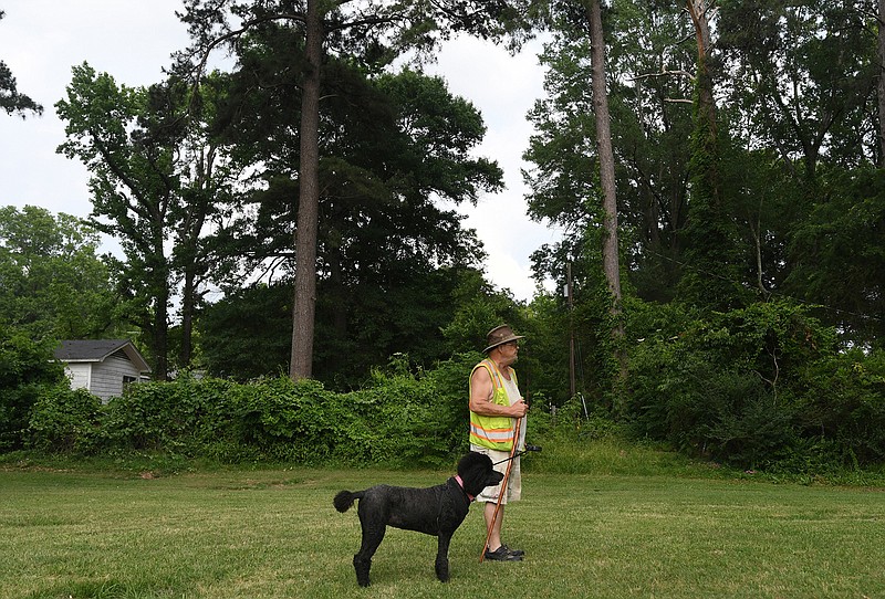 Henry McGinnis and his poodle Jazzy glance over at Big Jake's Bar-B-Que as the smell of barbecue floats through the park on their walk Thursday at Beverly Park. "I've taken her to work with me everyday for nine years now. She's a best friend," McGinnis said.