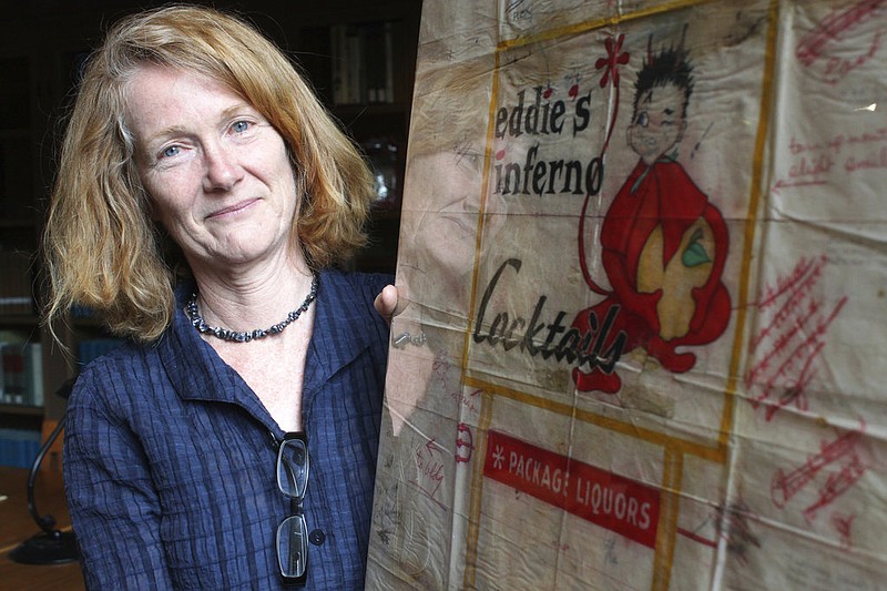 In this Tuesday, May 9, 2017, photo University of New Mexico associate professor of sculpture Ellen Babcock holds one of the neon design sketches she found among old business files belonging to Zeon Signs in Albuquerque, N.M. The sketches include designs for some of the most memorable neon signs along historic Route 66 in Albuquerque and elsewhere. They are now preserved at the university's Center for Southwest Research. 