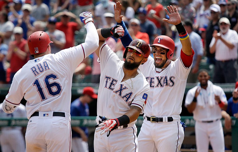 Texas Rangers Ryan Rua (16) celebrates his 3-run homer with teammates Rougned Odor, center, and Robinson Chirinos during the fifth inning of a baseball game against the Philadelphia Phillies in Arlington, Texas, Thursday, May 18, 2017.