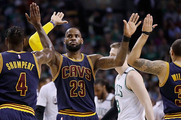 Cavaliers forward LeBron James trades high-fives with teammates during the first half of Friday night's Game 2 of the Eastern Conference finals against the Celtics in Boston.
