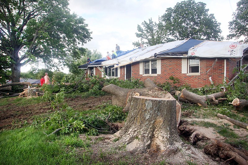 Work to repair damage and protect the home of Nichole and Cleo Scheperle continues on Saturday, May 20, 2017 after two trees fell onto their house during storms Friday in Wardsville.  