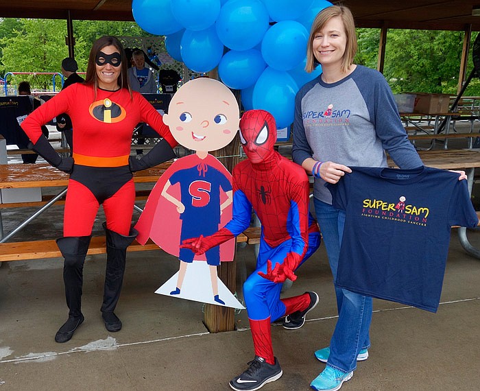 Volunteers set up Saturday, May 20, 2017 at the pavilion in Fulton's Memorial Park and sold T-shirts with the Super Sam Foundation's new logo. Shown are Mrs. Incredible (Chelsey Flynn, volunteer), Spider-Man (Tanner Lorentz, volunteer), and Kelly Nickelson, board member. 