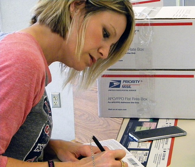 Hatton-McCredie Elementary parent-teacher organization member Rebecca Green fills out information for four of the seven care packages bound for U.S. soldiers deployed in South Korea.