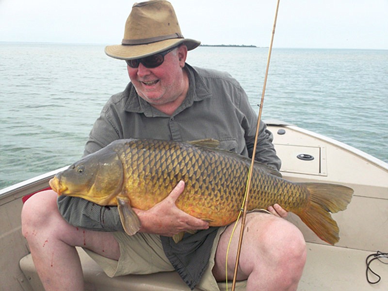Beaver Island's Chamber of Commerce director Steve West shows off a 31-pound carp caught on a fly.