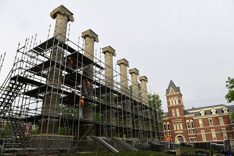 In this Wednesday, May 17, 2017 photo, workers assemble scaffolding around the columns on the Francis Quadrangle at the University of Missouri campus in Columbia, Mo. The six columns, which were built in 1842, have been battered by weather and students over the years.