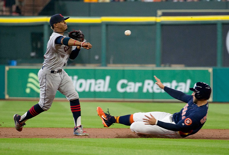 Cleveland Indians shortstop Francisco Lindor, left, makes the double-play throw to first as Houston Astros' George Springer is out at second base in the first inning of a baseball game Sunday, May 21, 2017, in Houston.