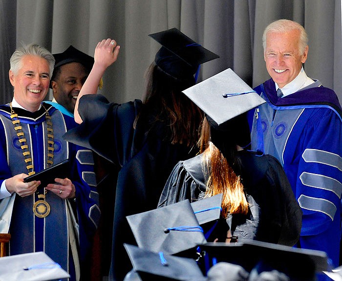 President David Greene, left, and commencement speaker former U.S. Vice President Joe Biden Jr. smile at graduates as they receive their diplomas Sunday during Colby College commencement ceremonies in Waterville, Maine.