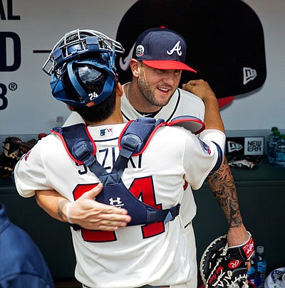 Matt Adams is embraced by Braves catcher Kurt Suzuki in the dugout before Sunday's game against the Nationals in Atlanta. The Braves acquired Adams from the Cardinals on Saturday.