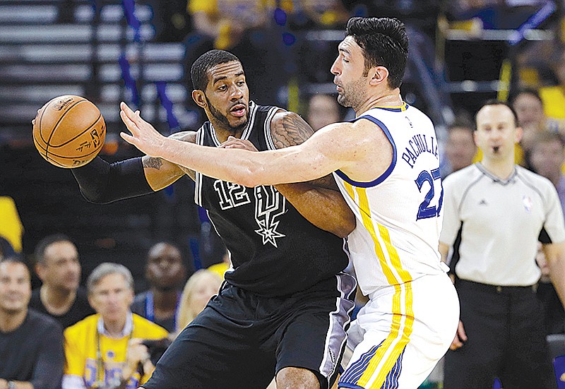 San Antonio Spurs' LaMarcus Aldridge, left, is defended by Golden State Warriors' Zaza Pachulia during Game 2 of the Western Conference finals May 16 in Oakland, Calif.