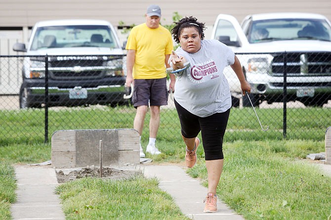 Michelle Johnson practices her throw playing horseshoes at Washington Park. Johnson has been playing for about a year and became involved through her cousin.
