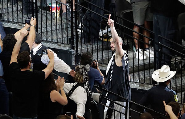 Spurs guard Manu Ginobili (right) signals to fans as he walks off the court Monday after Game 4 of the Western Conference finals against the Warriors in San Antonio. Golden State won 129-115, sweeping the four-game series against the Spurs.