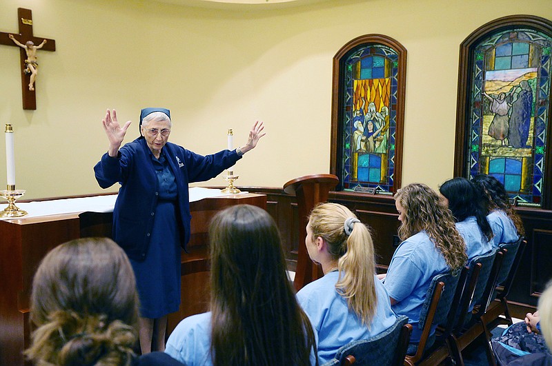 In this May 8, 2017 photo, Sister Natalie Marengo blesses the Reicher Catholic High School softball team in Waco, Texas. She will be leaving after thirty years as a teacher, mentor, alumni record keeper and sports supporter. She will be the last nun at the high school until officials can figure out what to do next.