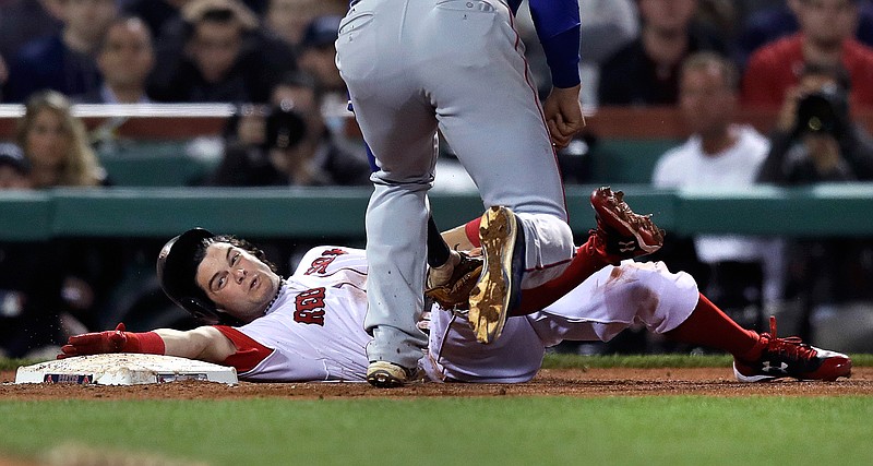 Boston Red Sox's Andrew Benintendi stretches to reach the base as he's tagged out by Texas Rangers third baseman Joey Gallo while trying to advance during the fifth inning of a baseball game at Fenway Park in Boston, Tuesday, May 23, 2017. 