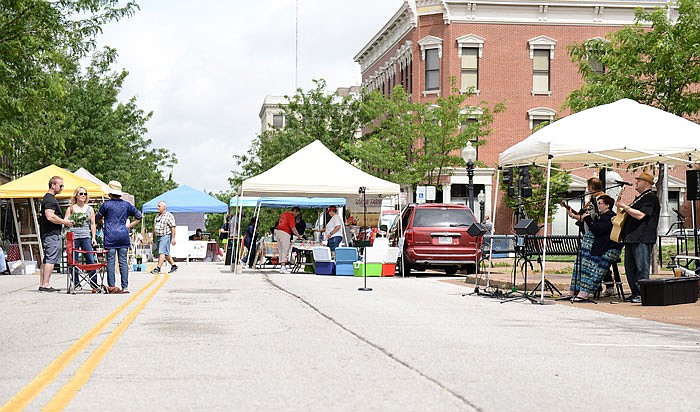 Residents walk the streets and browse through fresh produce as local area band, Apostle's Creek, performs last week during the Capital City Farmers Market.