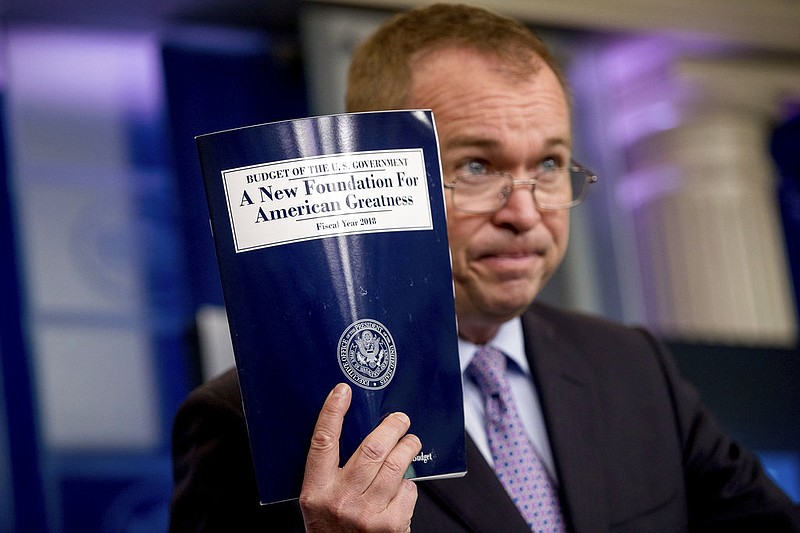 Budget Director Mick Mulvaney holds up a copy of President Donald Trump's proposed fiscal 2018 federal budget as he speaks to members of the media in the Press Briefing Room of the White House in Washington, Tuesday, May 23, 2017. 