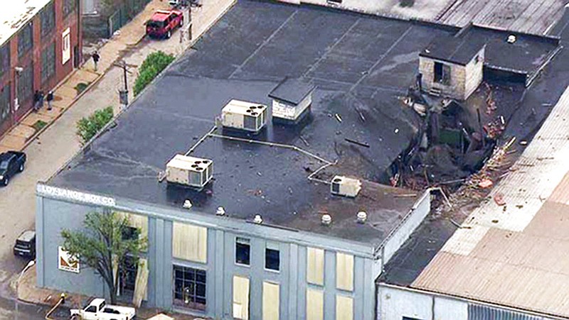 This April 3, 2017 file photo from video provided by KMOV shows damage to the roof of the Loy-Lange Box Co. in St. Louis after a steam condensation tank exploded and flew before crashing through the roof of a nearby laundry business.