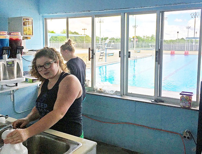 Oestreich Swimming Pool summer workers Lauren Nichols, front, and Suzie Whitmar help prep the concessions area Wednesday for Saturday's opening day.
