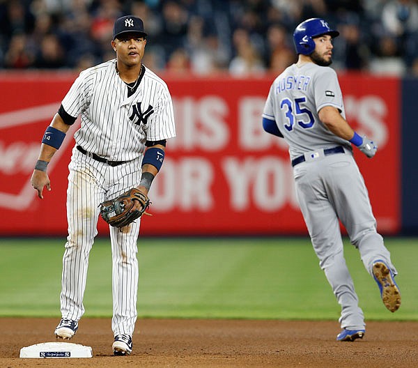 Yankees second baseman Starlin Castro and Royals designated hitter Eric Hosmer look toward first base for the outcome of a play during Wednesday night's game at Yankee Stadium in New York.