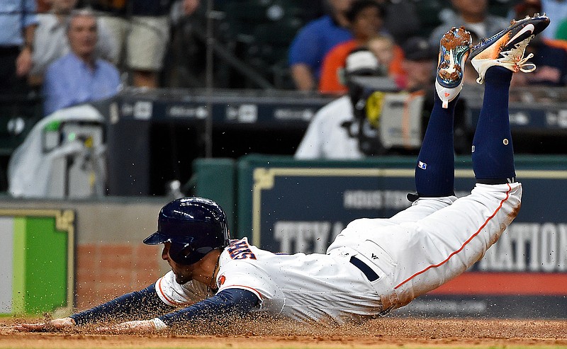 Houston Astros' George Springer slides safely to score a run on Evan Gattis' sacrifice fly during the third inning of a baseball game, Wednesday, May 24, 2017, in Houston. 