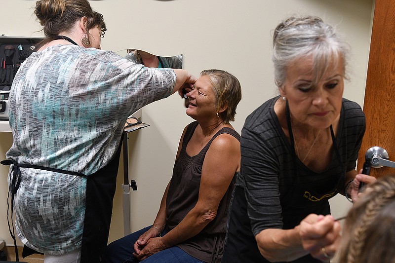 Cathy Bowker, center, has makeup professionally applied by Jamie Sheets, left, while Joyce Miller works on another woman during Spa Day on Thursday for women from Randy Sams' Outreach Shelter at the Beauty and Wellness Center. 
