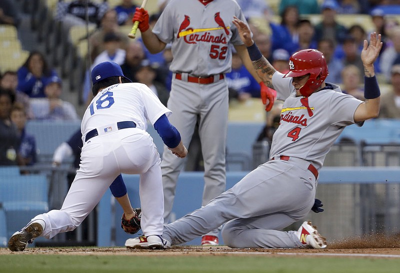 Los Angeles Dodgers pitcher Kenta Maeda, of Japan, tags St. Louis Cardinals' Yadier Molina out at the plate while try to score on a wild pitch during the first inning of a baseball game in Los Angeles, Thursday, May 25, 2017. 