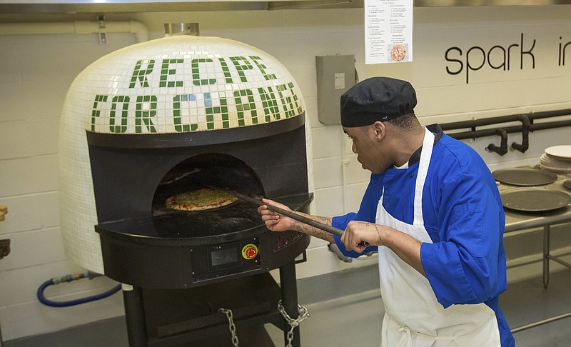 Inmate Marcus Clay pulls pizza from oven May 23, 2017, at the Cook County Jail in Chicago. Inmates in the jail's medium-security Division 11 are now allowed to order pizzas made by participants in the jail's Recipe for Change program, which teaches inmates about cooking and nutrition.