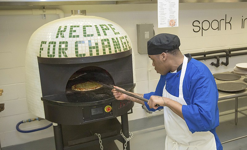 Inmate Marcus Clay, pulls pizza from oven May 23 at the Cook County Jail in Chicago. Inmates in the jail's medium-security Division 11 are now allowed to order pizzas made by participants in the jail's "Recipe for Change" program, which teaches inmates about cooking and nutrition.