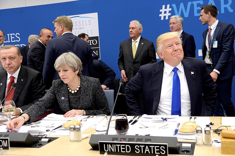 US President Donald Trump, right,  reacts as he sits next to Britain's Prime Minister Theresa May, centre and Turkish President Recep Tayyip Erdogan as they participate in a working dinner meeting, during the NATO summit of heads of state and government, at the NATO headquarters, in Brussels on Thursday, May 25, 2017. US President Donald Trump inaugurated the new headquarters during a ceremony on Thursday with other heads of state and government.