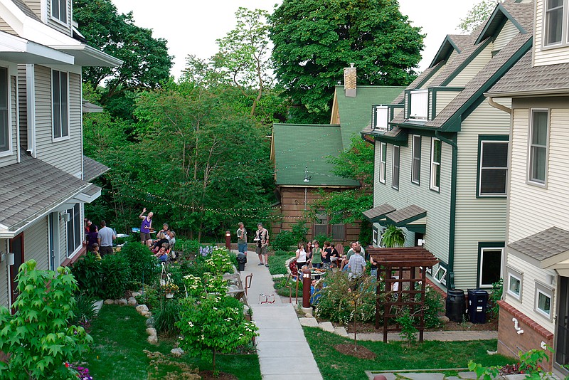This undated photo provided by Joanna Vander Plaats shows residents of Newberry Place Cohousing Community in Grand Rapids, Mich. Cohousing developments are designed to foster interaction between neighbors. The developments are generally built to be pedestrian-friendly with parking out of view. Front Porches face each other so neighbors can more easily talk. 