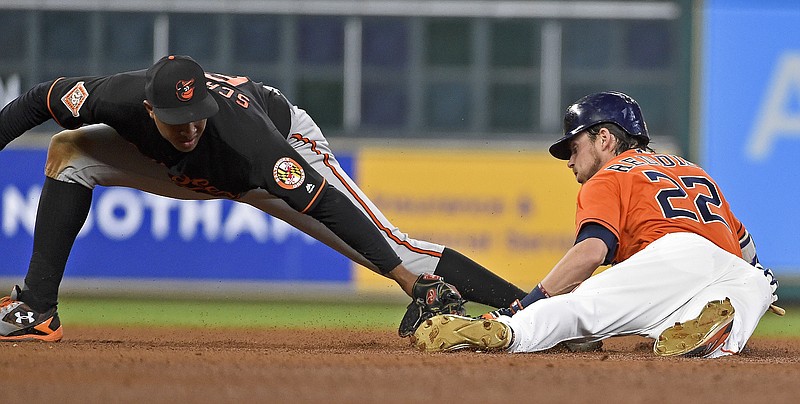 Houston Astros' Josh Reddick, right, slides past Baltimore Orioles second baseman Jonathan Schoop for a double during the fifth inning of a baseball game, Friday, May 26, 2017, in Houston. 