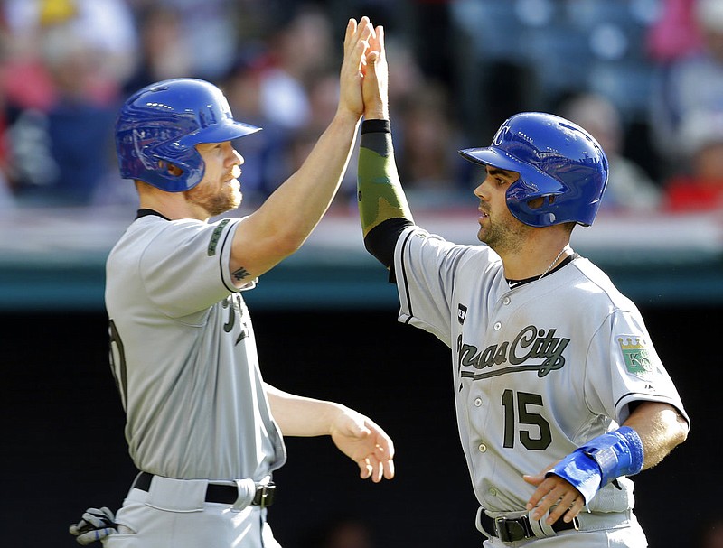 Kansas City Royals' Brandon Moss, left, and Whit Merrifield celebrate after they scored on a two-run double by Alcides Escobar in the sixth inning of a baseball game against the Cleveland Indians, Saturday, May 27, 2017, in Cleveland. 