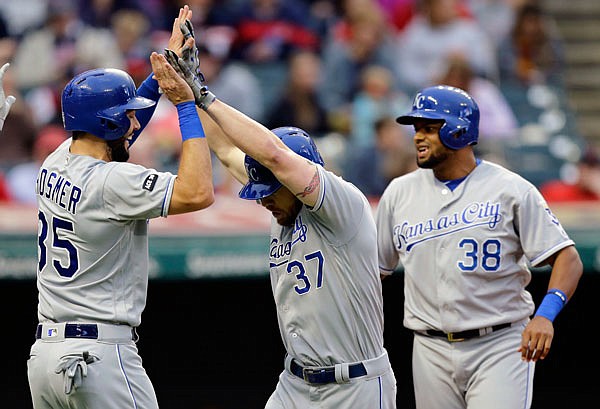 Brandon Moss is congratulated by Eric Hosmer (35) after Moss hit a three-run home run in the fourth inning of Friday night's game against the Indians in Cleveland. Jorge Bonifacio (38) scored on the play.