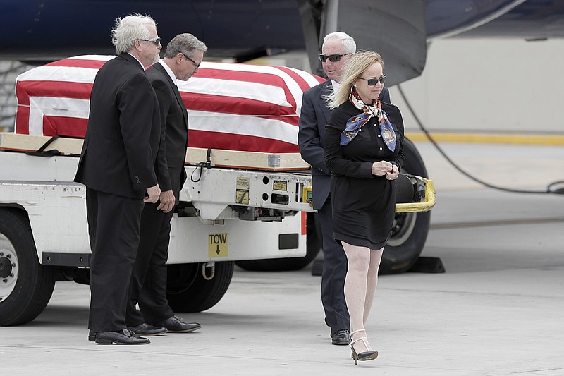 Deborah Crosby, right, walks away from her father's casket after its arrival to the airport Friday in San Diego. Her brothers, Douglas Crosby, left, John Crosby, second from left, and Steven Crosby look on. Crosby spent more than half a century on getting her father's remains recovered from Vietnam after his Navy plane was shot down in 1965.
