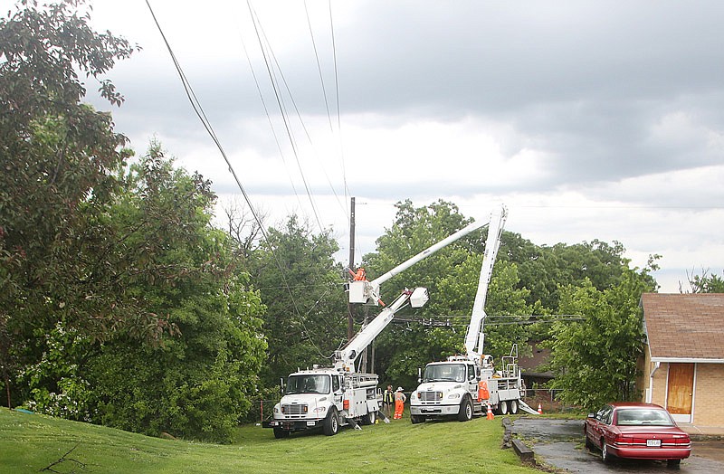 In this May 19, 2017 photo, crews work on downed utility lines following a severe thunderstorm in Linn, Mo.