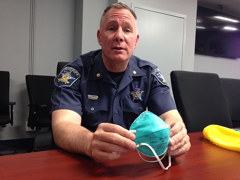 This May 25, 2017 photo shows Harford County Major John R. Simpson is seen at the Harford County Sheriff's Office, MD., holding up elements of a protective suit that the sheriff's office is now providing to deputies sent to crime scenes involving heroin and synthetic opioids. After a deputy accidentally overdosed while at a drug scene, the department rushed to procure protective gear and establish protocols for officers responding to drug scenes.