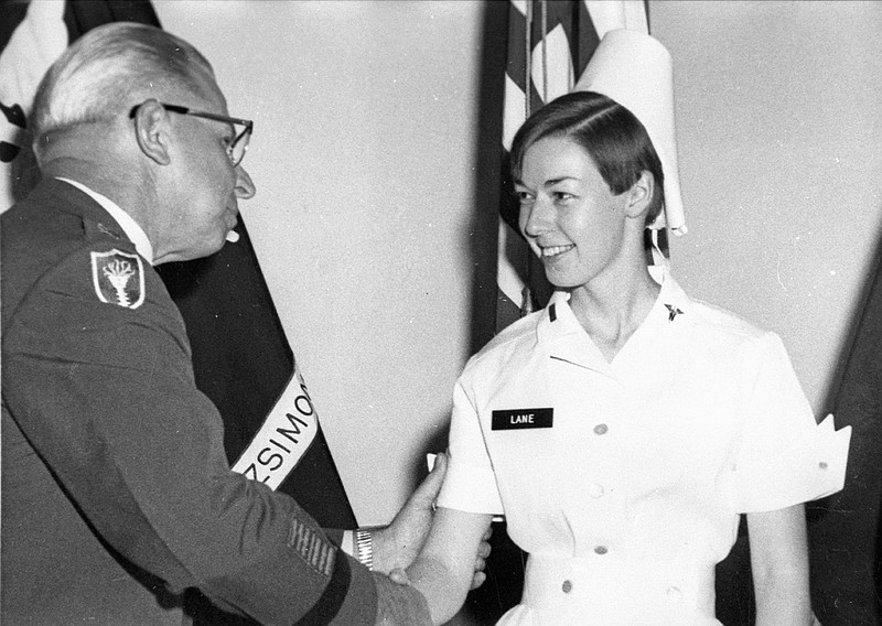 In this Aug. 30, 1968, photo provided by Philip Bigler, author of Hostile Fire, U.S. Army nurse Sharon Lane is congratulated by a military official as she's promoted to first lieutenant in Aurora, Colo. Lane, the only American servicewoman killed by hostile fire in the Vietnam War, has been immortalized in books, statues and a television show, and veterans still gather at her grave five decades after her death.