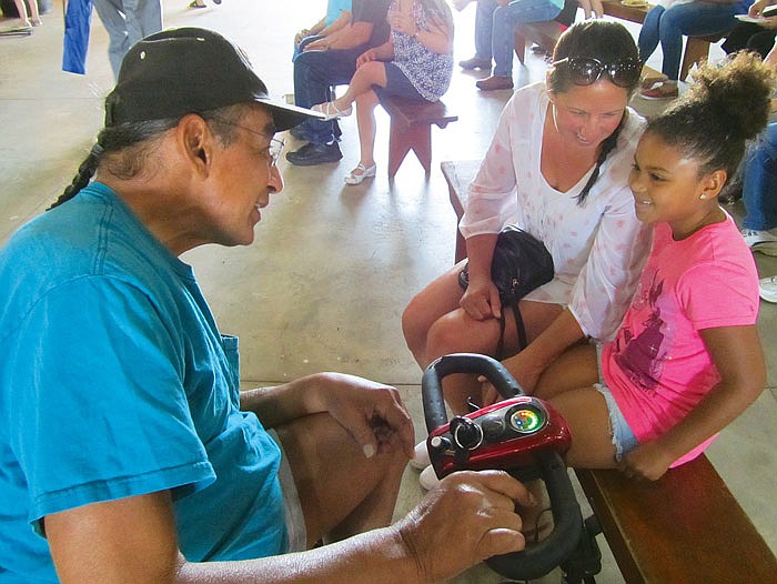 At left, Larry Sellers chats with 7-year-old Ava Smith as her mother, Darcie Tone-Pah-Hote, looks on during Sunday's Pow Wow for the People event at the Jefferson City Jaycees Cole County Fairgrounds. Sellers was the guest of honor at the event. He is a Native American actor who played "Cloud Dancing" on the 1990s television show "Dr. Quinn, Medicine Woman." 