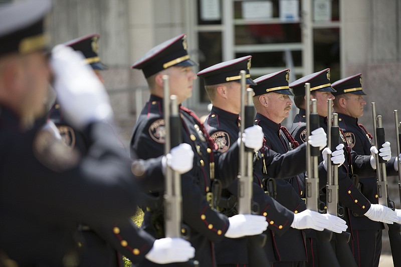 Texarkana, Texas, Police Officer Jack Crye and other members of the TTPD Honor Guard stand at attention as taps is played Monday during the Memorial Day ceremony May 28, 2017, on the Miller County Courthouse lawn in Texarkana, Ark. 