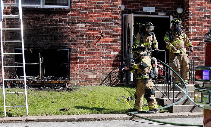 Jefferson City firefighters depart the burned apartment unit Monday at 554 Senate Court. The fire left one man hospitalized due to smoke inhalation.