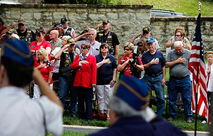 Patrons, veterans and law enforcement alike salute the American flag as a bugler sounds 'Taps' bugle May 29, 2017 during Memorial Day services at National Cemetery.