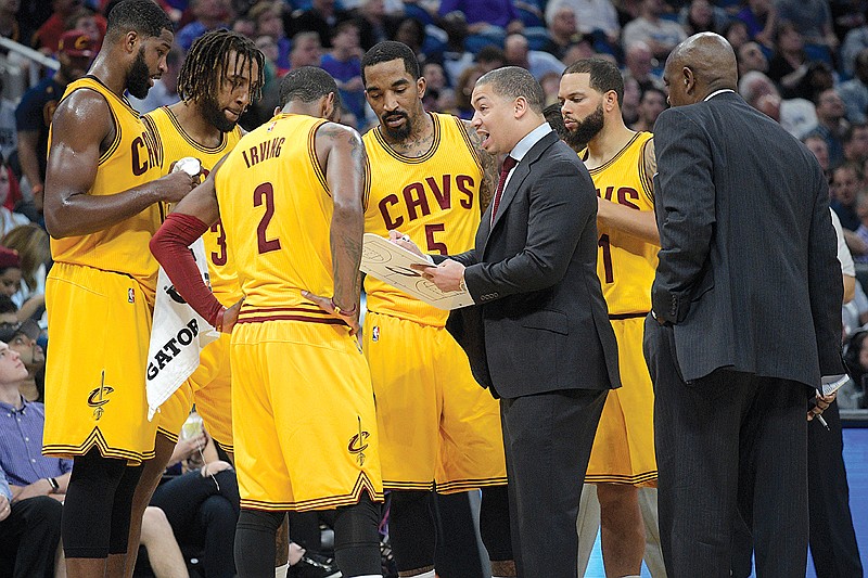 Cleveland Cavaliers head coach Tyronn Lue, center, talks to his players during a timeout in the second half  against the Orlando Magic on March 11 in Orlando, Fla. Lue would prefer less attention, but it comes with the territory as coach of the defending NBA champions. Cleveland is back in the NBA Finals, and the Cavaliers acknowledge they probably wouldn't be in a position to win another title if not for Lue's calming influence.