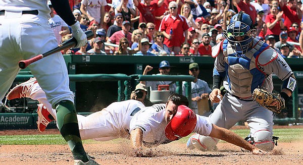 Paul DeJong of the Cardinals is tagged out at home by Dodgers catcher Yasmani Grandal during the seventh inning of Monday afternoon's game at Busch Stadium.