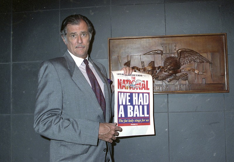 In this June 12, 1991, file photo, Frank Deford, editor and publisher of The National Sports Daily, holds a proof of the final front page of the newspaper after a news conference at the paper's offices in New York. Award-winning sports writer and commentator Frank Deford has died. He was 78. Deford died Sunday, May 28, 2017, in Key West, Florida, his family confirmed.