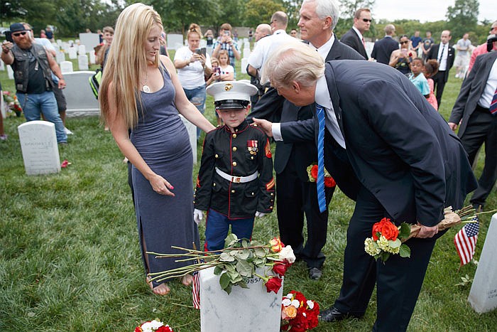 Brittany Jacobs, left, watches Monday as her 6-year-old son Christian Jacobs meets President Donald Trump and Vice President Mike Pence in Section 60 of Arlington National Cemetery in Arlington, Virginia. Jacob's father, Marine Sgt. Christopher Jacobs, was killed in 2011.