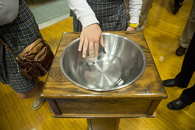 In this Nov. 20, 2013 file photo, holy water sits at the doorway to the gymnasium at Helias Catholic High School as students and grandparents settle in for Grandparents Day mass. 