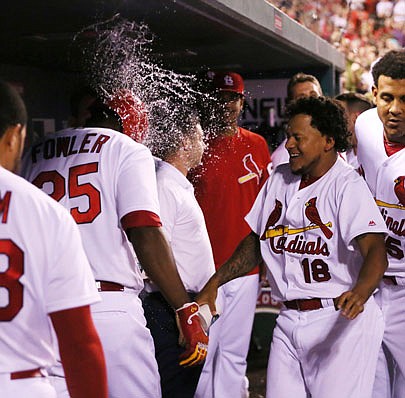 Dexter Fowler is splashed by Cardinals pitcher Carlos Martinez in the dugout after he hit a solo home run in the eighth inning of Wednesday night's game against the Dodgers at Busch Stadium.