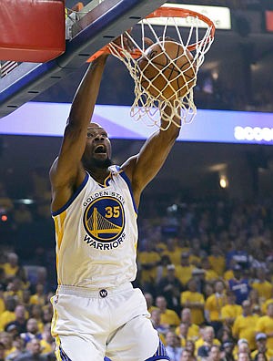 Kevin Durant of the Warriors dunks during Thursday night's game against the Cavaliers in Oakland, Calif.