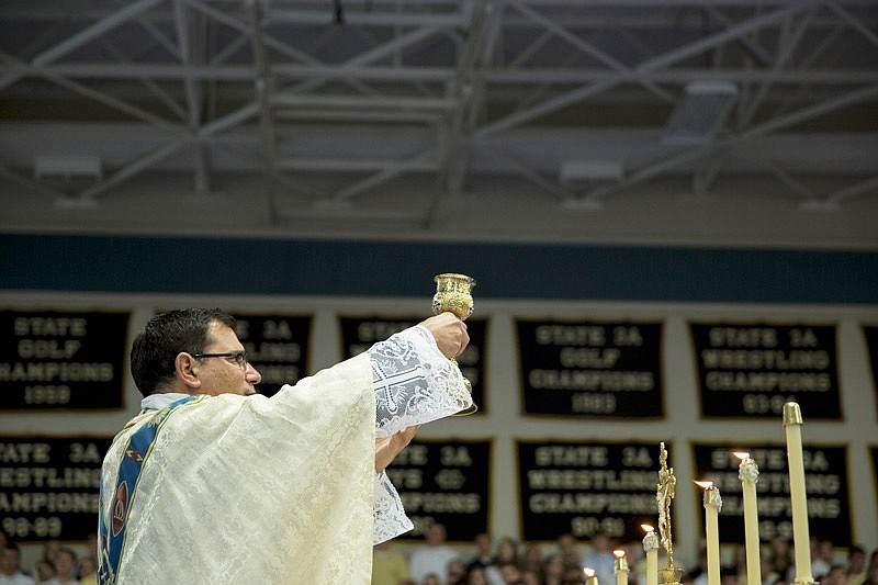 In this Nov. 20, 2013 file photo, Father Anthony Viviano presents communion to students and grandparents during the Grandparents Day mass at Helias Catholic High School in Jefferson City.