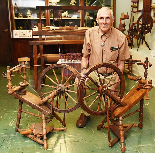 LeRoy Engelbrecht poses with two spinning wheels. The one on the
right he made in the early 1980s, and the other was brought to the
United States from Germany in 1857 by his ancestor.